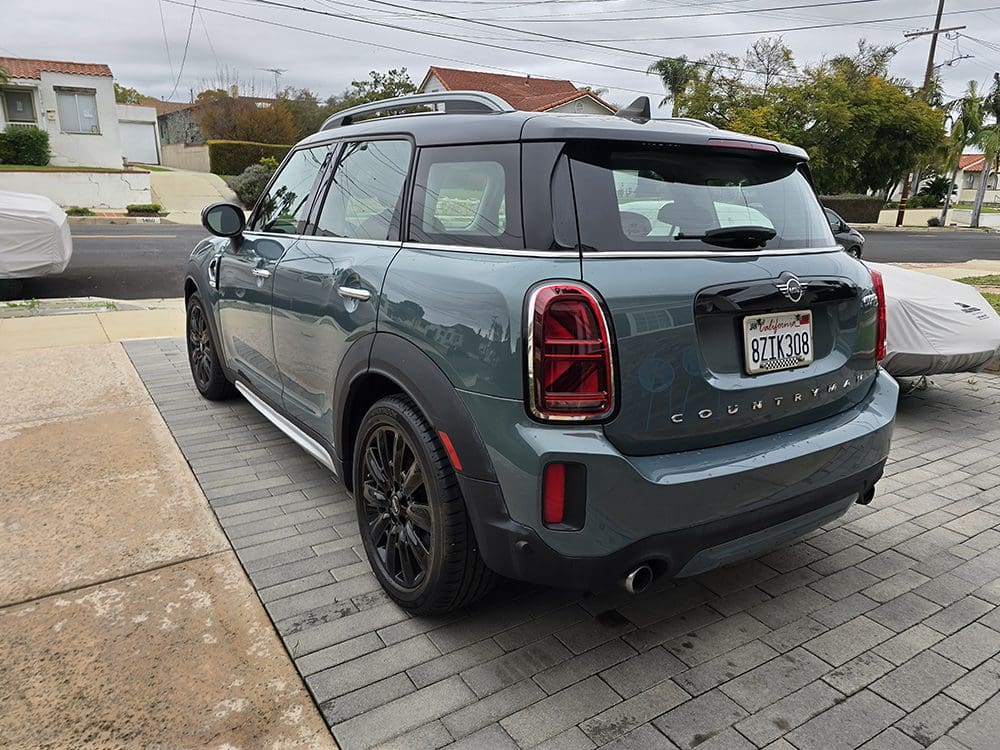 A blue Mini Cooper parked on a residential driveway.