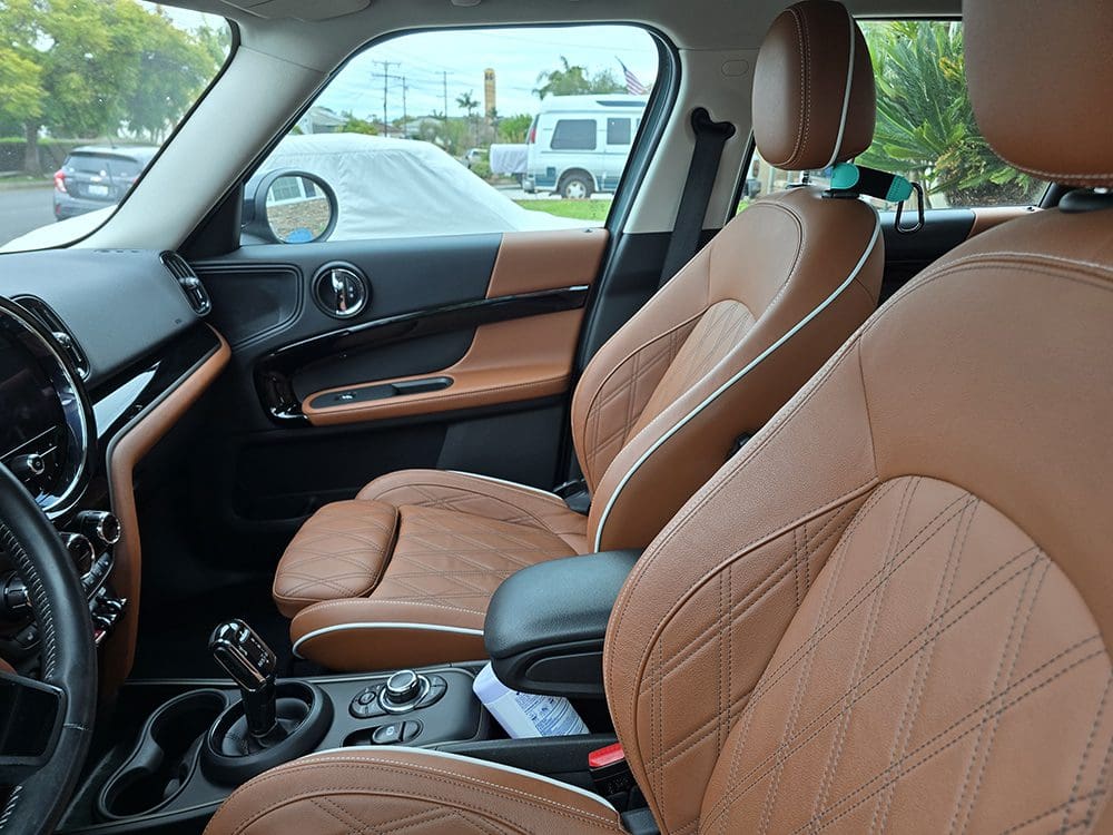 Interior of a car showcasing tan leather seats and modern dashboard.
