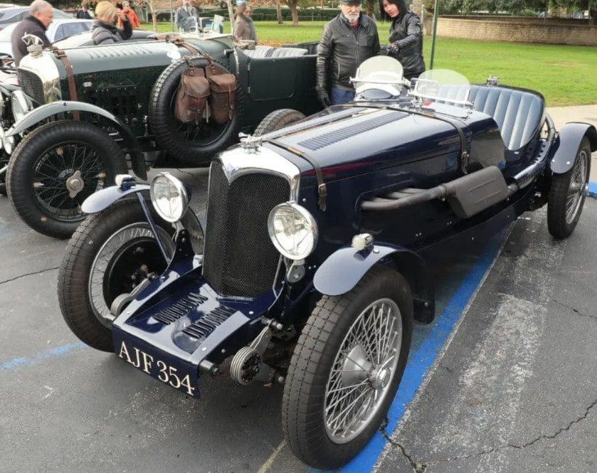 A vintage dark blue classic car displayed at an outdoor event.