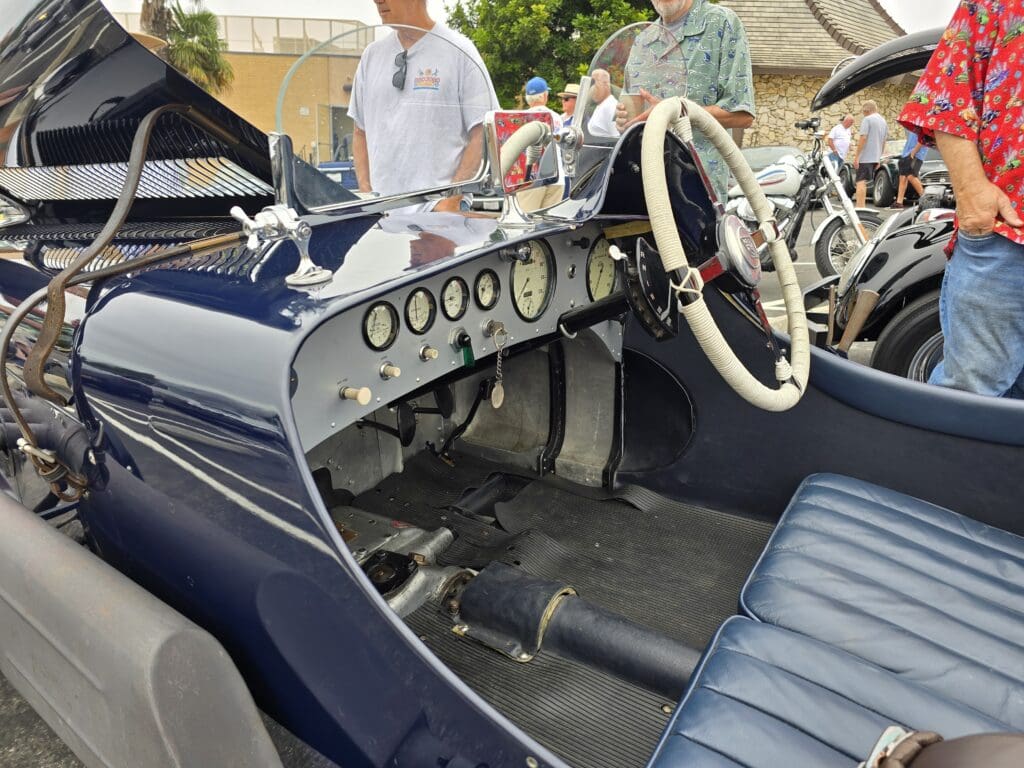 Interior of a vintage car showcasing classic gauges and a large steering wheel.