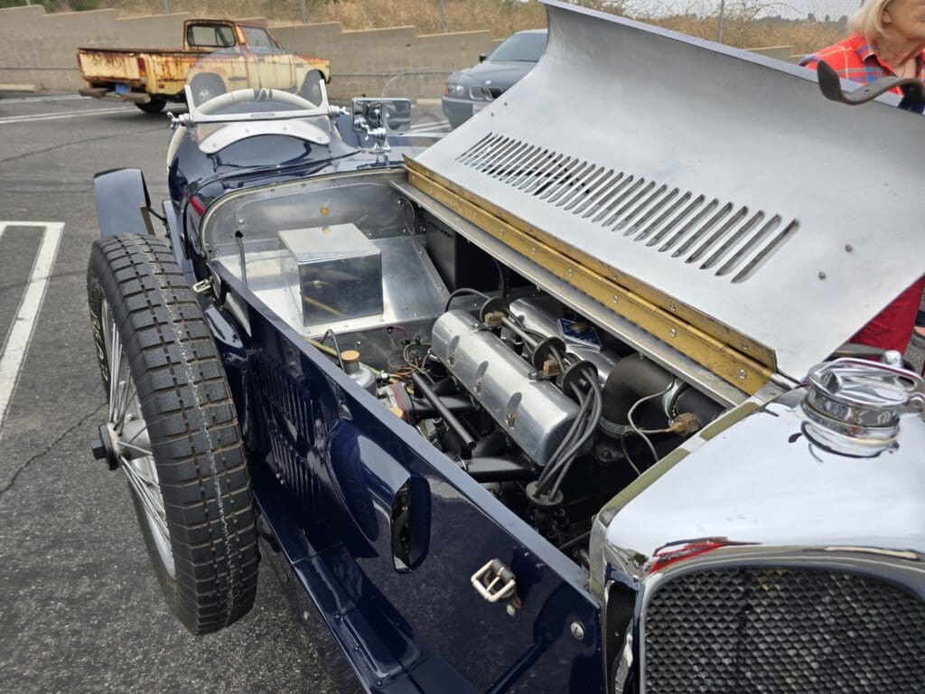 Classic vintage car engine with open hood showing intricate details.