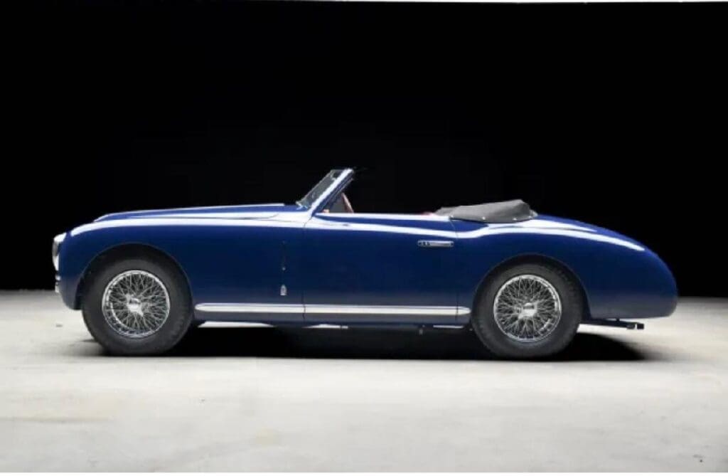 A classic blue convertible sports car shown from the side.
