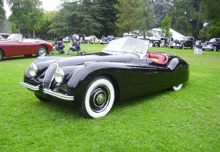 Classic black convertible car with whitewall tires on display.