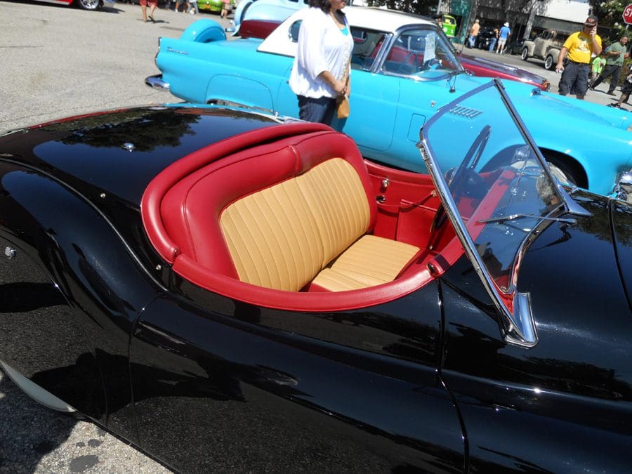 Classic black convertible with red and beige interior seats.