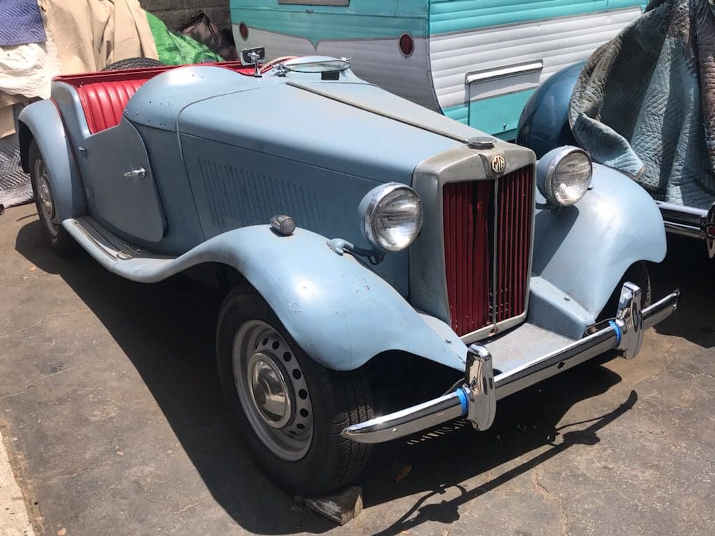 Vintage blue car with classic design and rounded headlights.