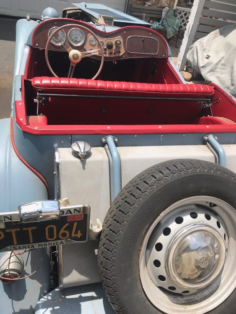 Rear view of a vintage car with a spare tire and classic license plate.