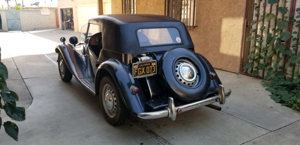 Classic vintage car with a spare tire mounted on the back.