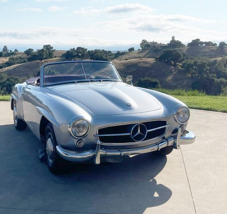 Classic silver Mercedes-Benz convertible parked outdoors on a sunny day.