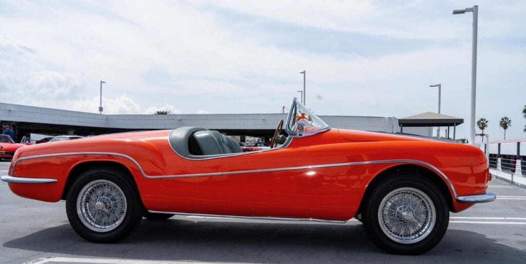 Classic red convertible car parked outdoors on a clear day.
