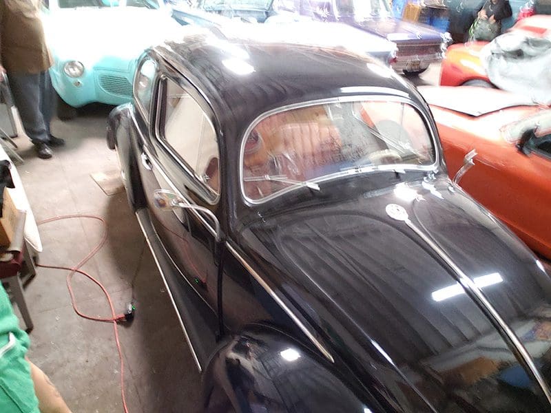 A classic black vintage car displayed indoors.
