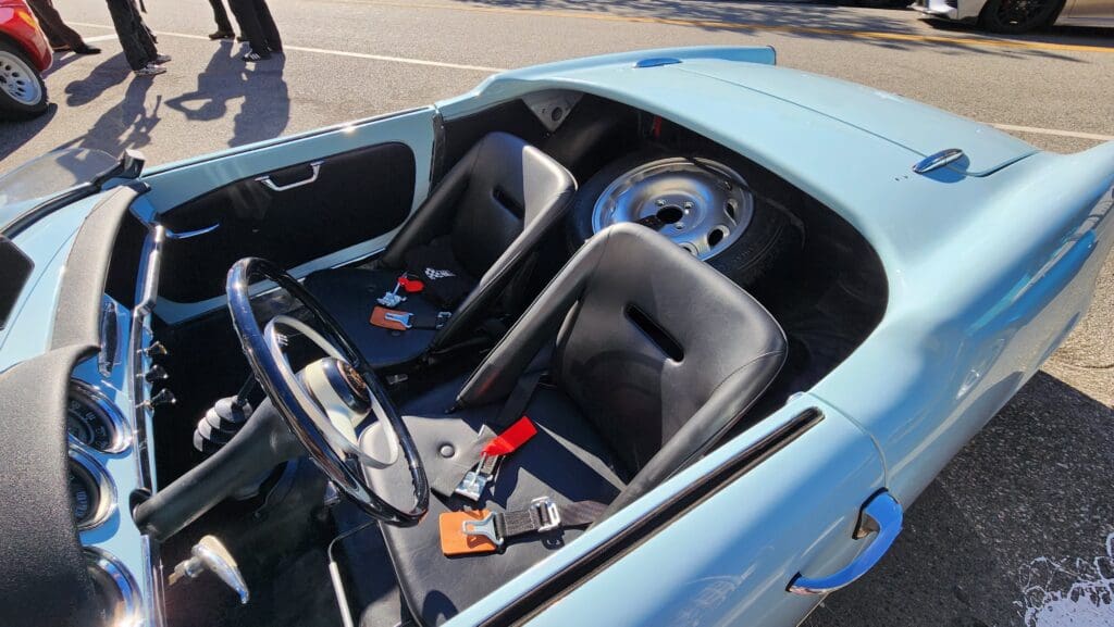 Light blue vintage convertible car parked outdoors on a sunny day.