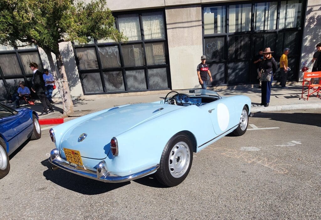 Light blue classic convertible parked on a sunny street.