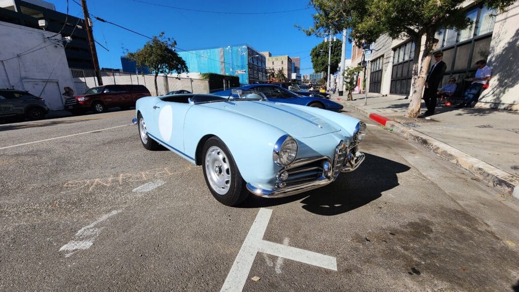 A light blue vintage convertible car parked on a city street.