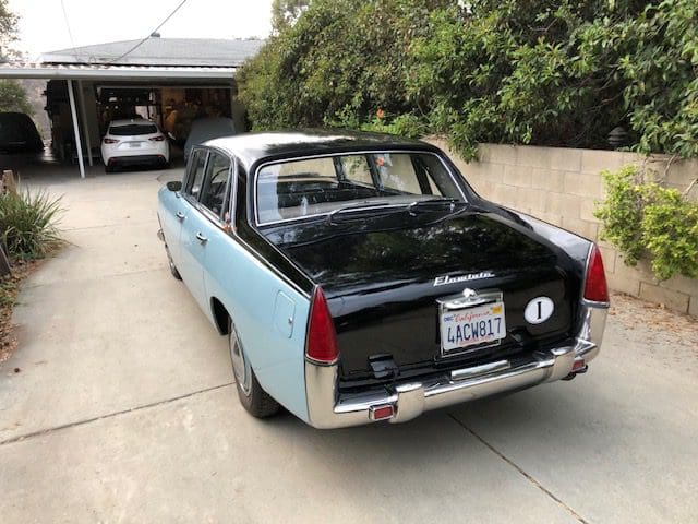 Classic two-tone vintage car parked in a driveway.