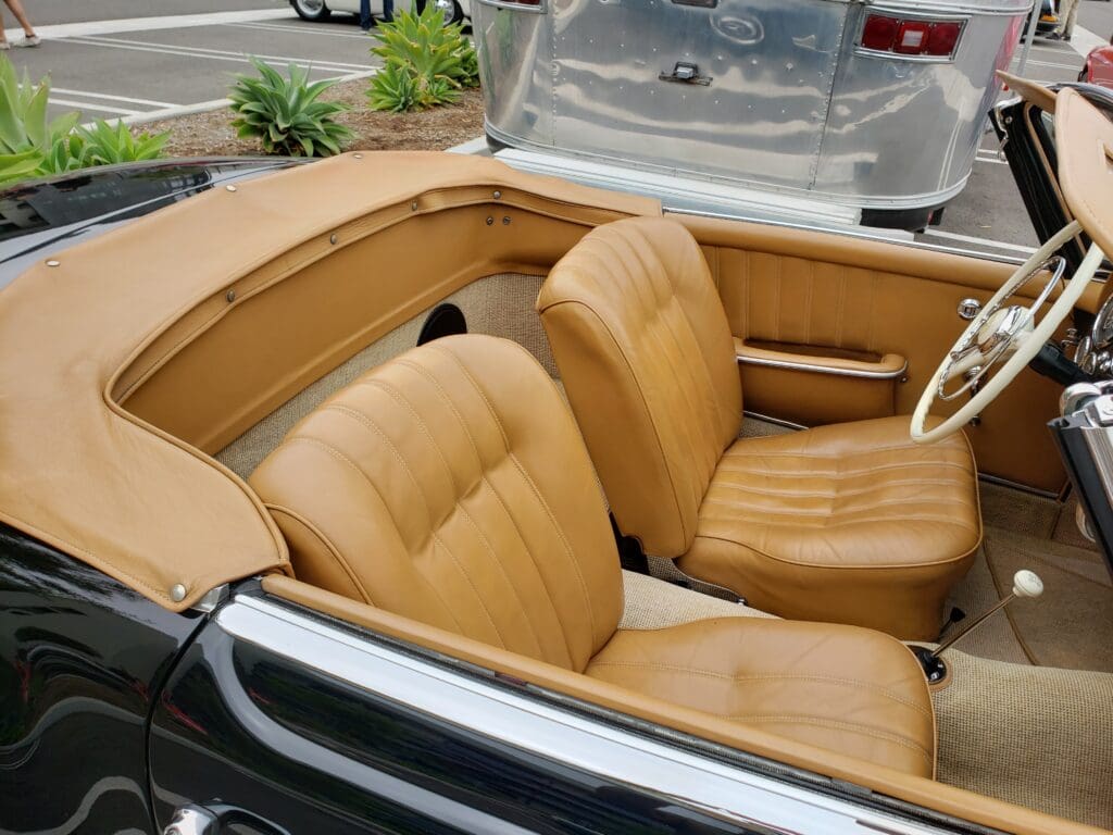 Interior of a vintage convertible car with tan leather seats.
