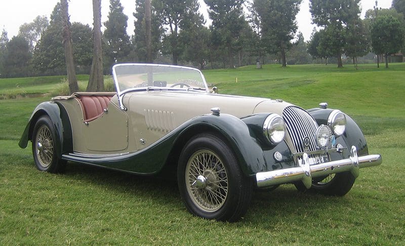 Classic vintage convertible car parked on grass.