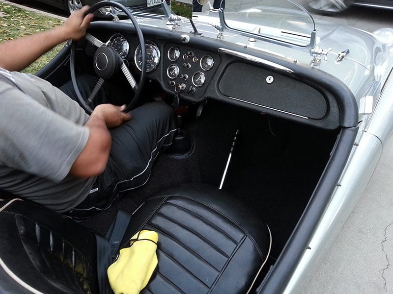 Interior view of a classic car showing black leather seats and dashboard.