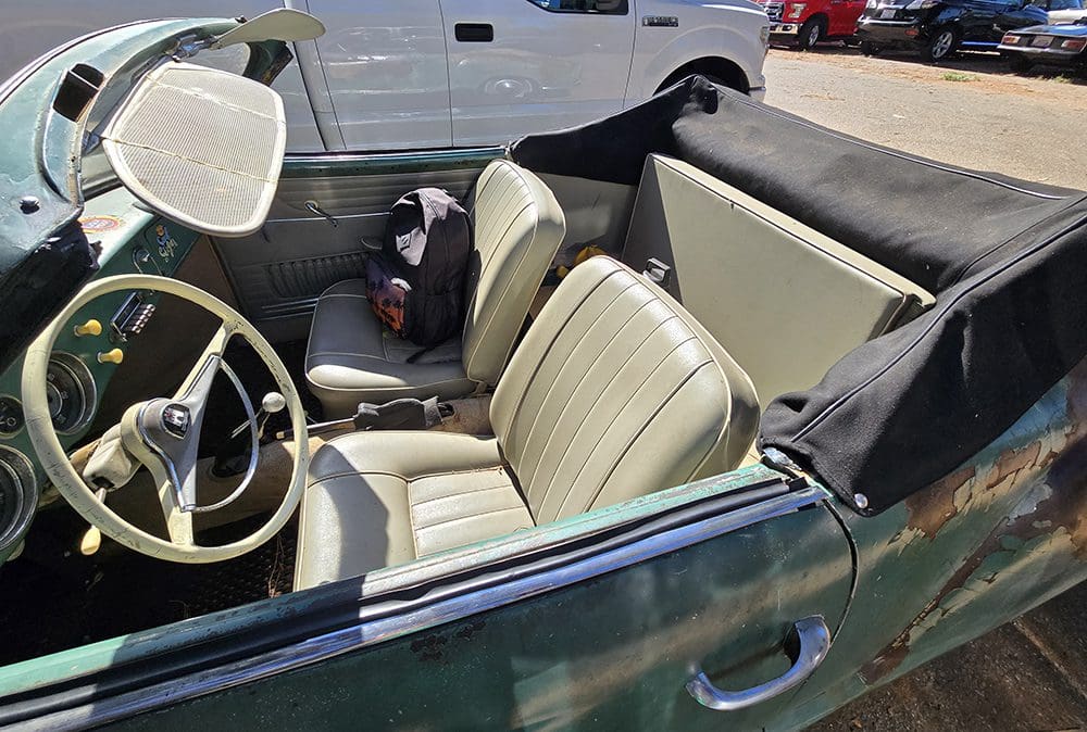 Interior of a vintage convertible car with beige leather seats.
