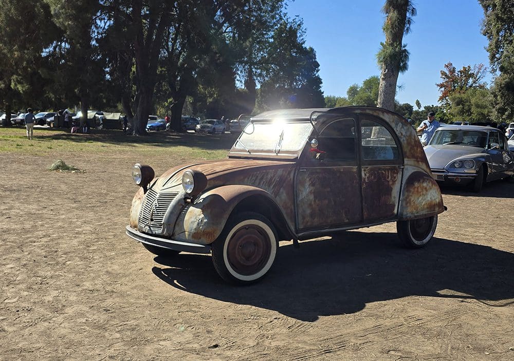 Classic vintage car parked on a sunny day in an open area.