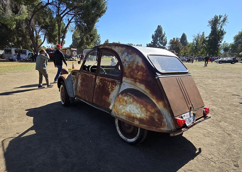 Classic vintage car parked on a sunny day in an open area.