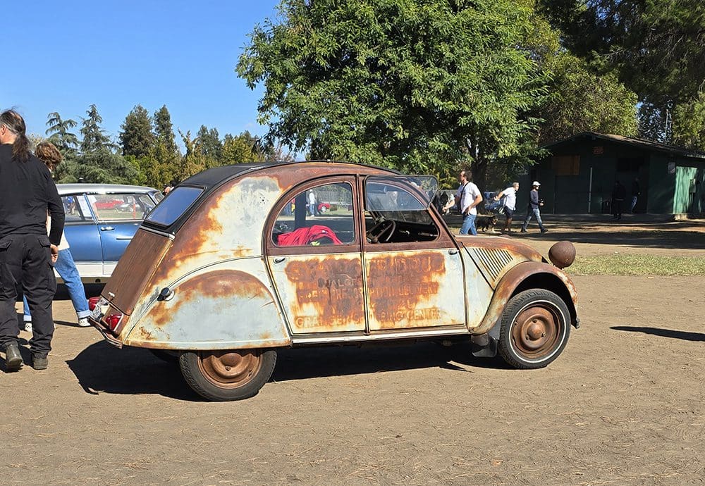 Rusty vintage car parked outdoors on a sunny day.
