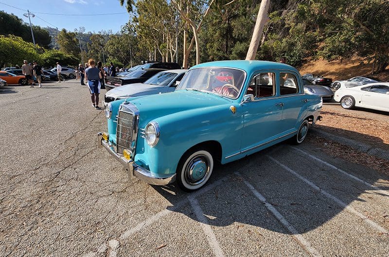 A vintage blue Mercedes-Benz parked outdoors at a car show.