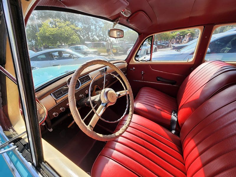 A vintage blue Mercedes-Benz parked outdoors at a car show.