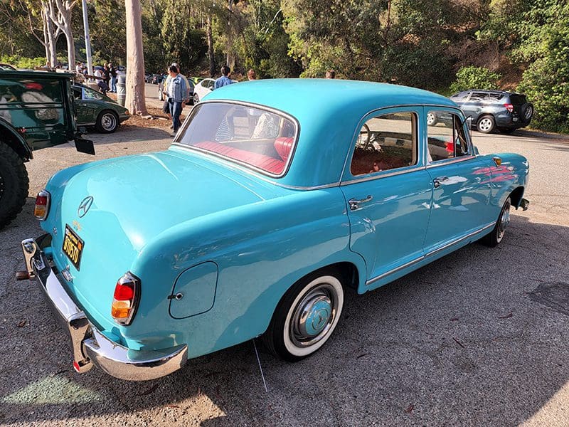 Vintage blue car parked on a sunny street.