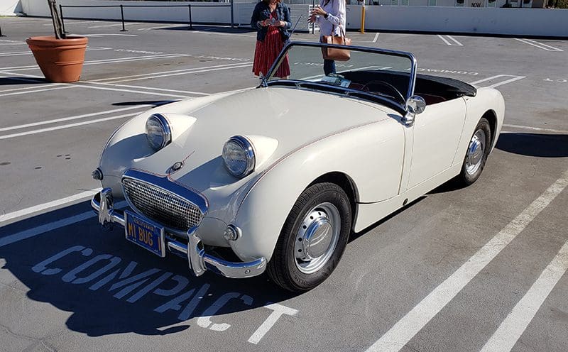 Classic white convertible parked outdoors on a sunny day.