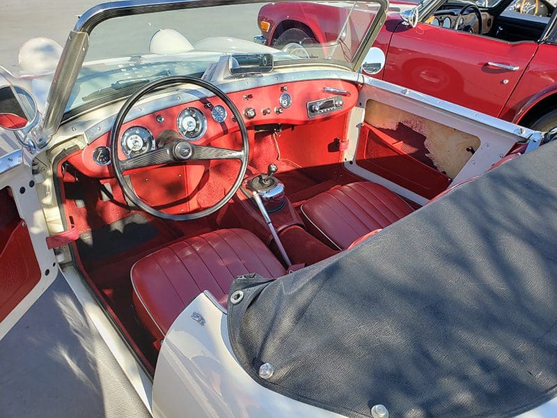Classic white convertible parked outdoors on a sunny day.