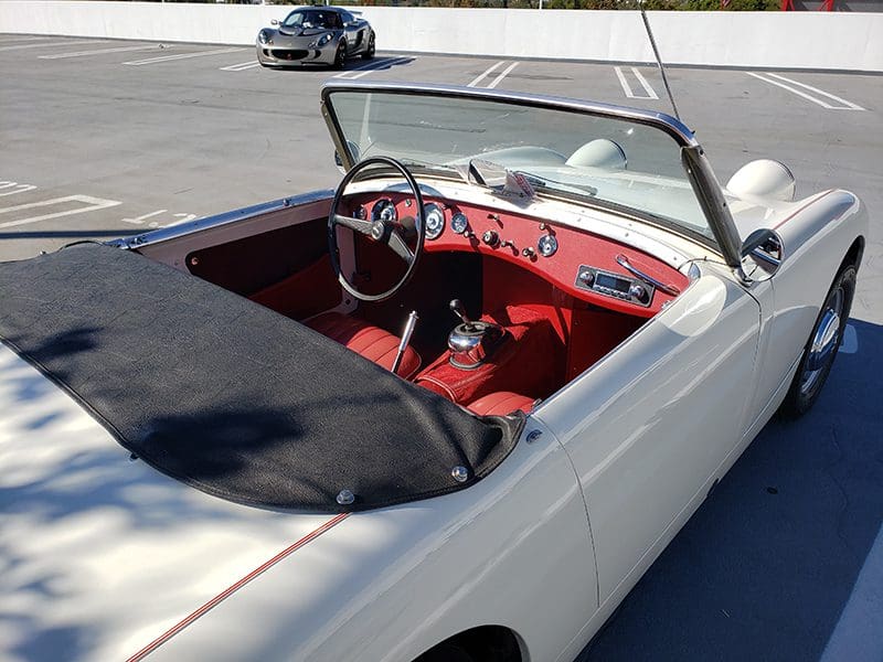 Classic white convertible parked outdoors on a sunny day.