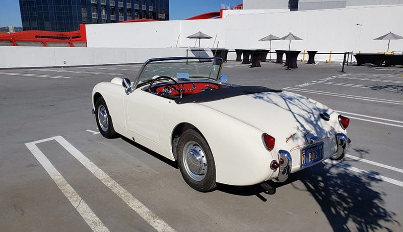 Classic white convertible parked outdoors on a sunny day.