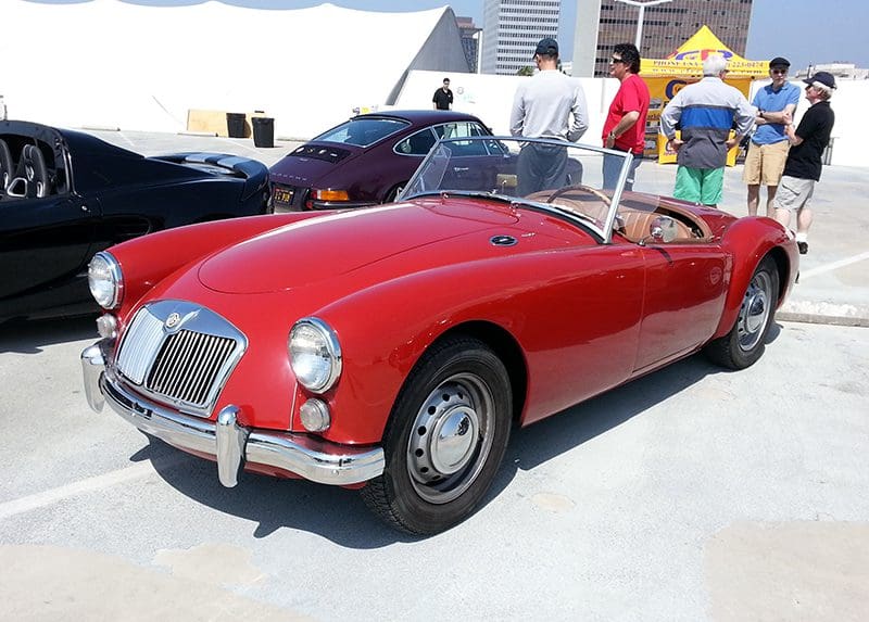 Classic red convertible sports car displayed outdoors on a sunny day.