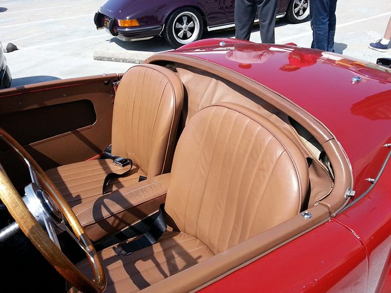 Close-up of a classic red convertible car with tan leather seats.