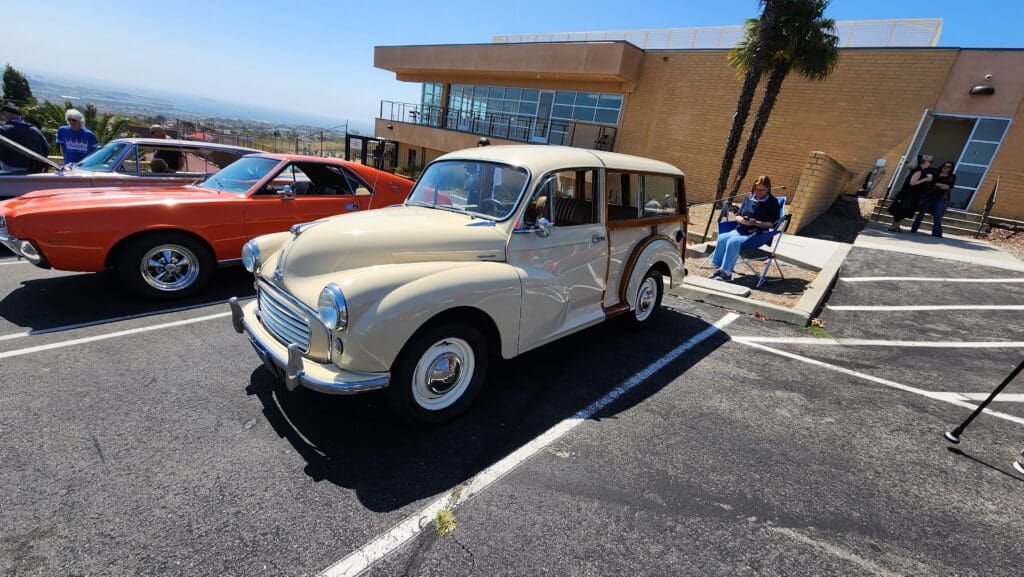 Classic cream-colored Morris Minor car parked outdoors on a sunny day.