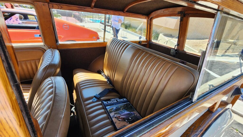 Vintage car interior with brown leather seats and classic design.