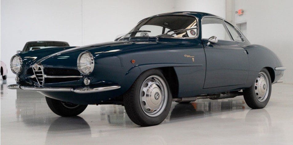 A classic dark blue vintage car with sleek curves and chrome details.