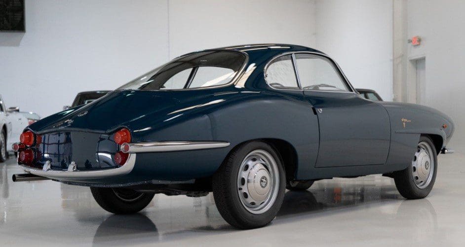 Classic dark green coupe car with vintage design.