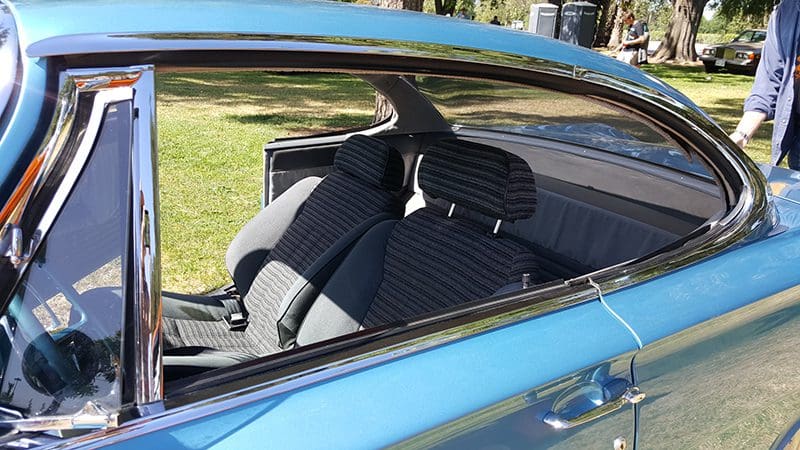 Person resting feet on car dashboard through open window.