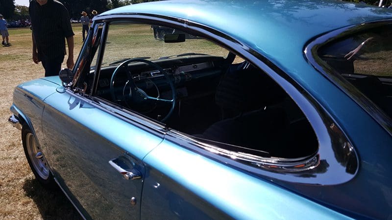 Close-up of a vintage blue car's interior through its open window.