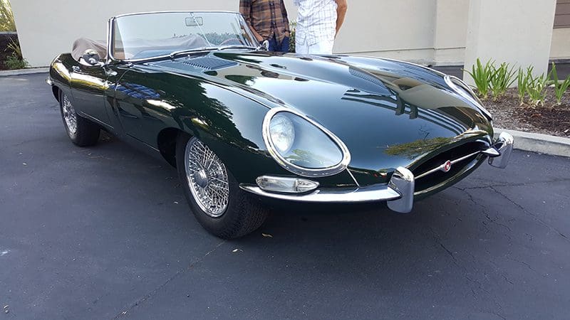 Classic dark green vintage sports car with chrome accents.