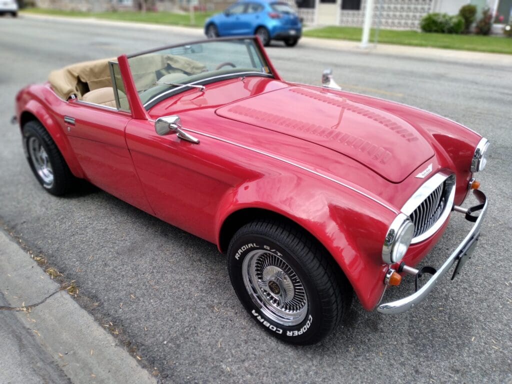 Classic red convertible parked on the street.