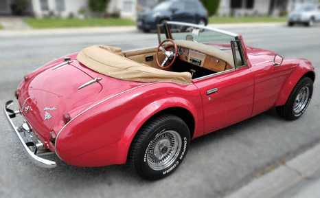 Red vintage convertible car parked on a street.