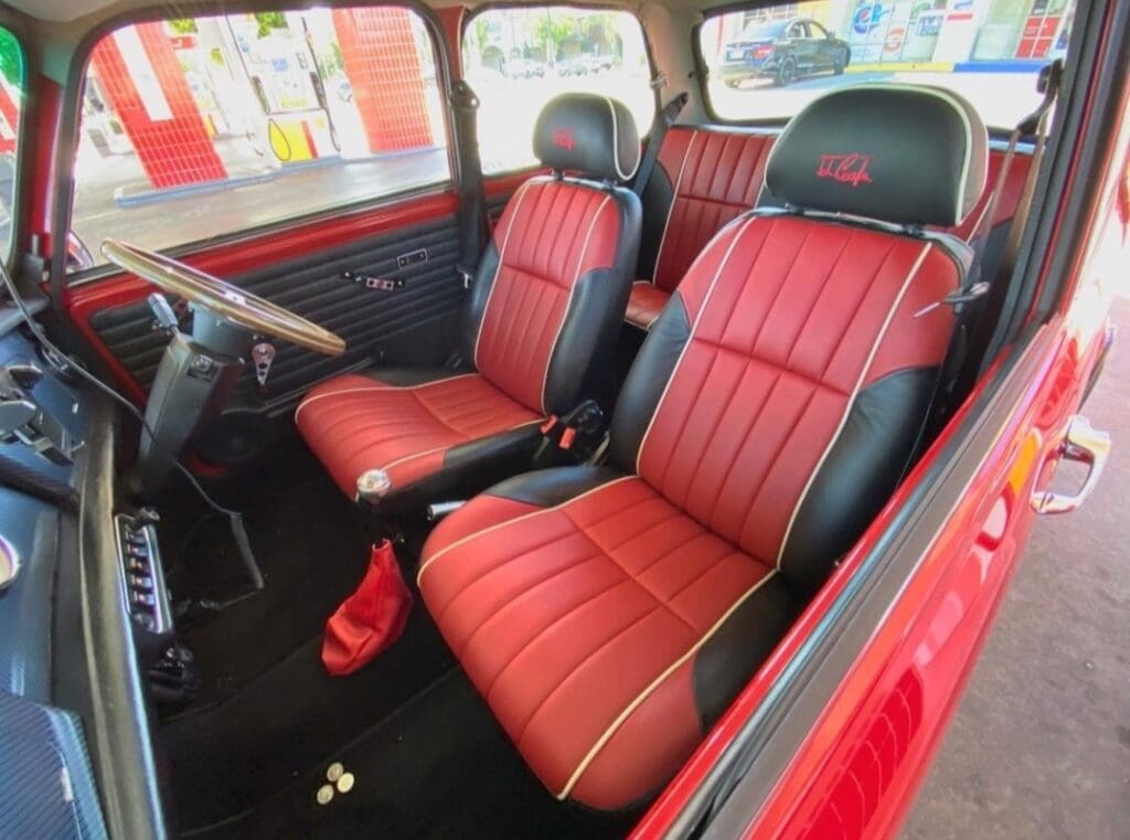 Red and black leather car seats in a vintage vehicle.