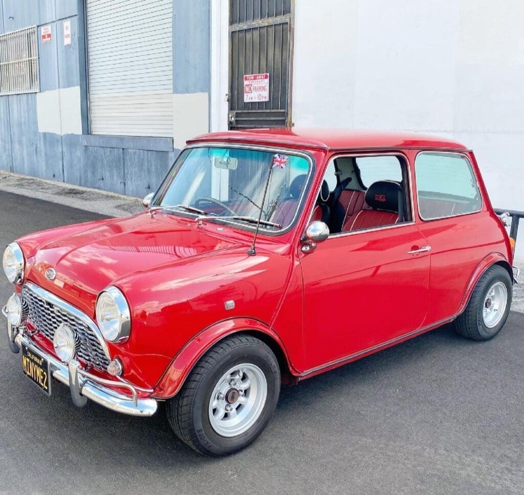 Classic red Mini Cooper parked on a street near a building.