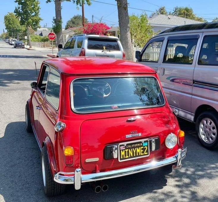Classic red Mini Cooper parked on a sunny street.