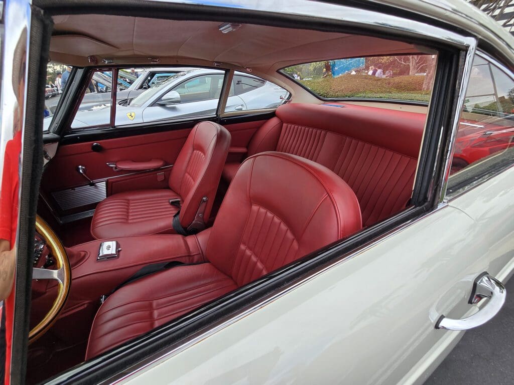 Classic car interior with red leather seats and vintage design.