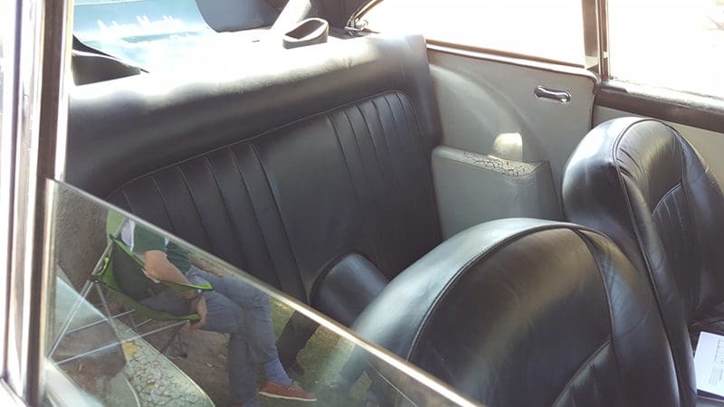 Interior view of a car's backseat with black leather upholstery.
