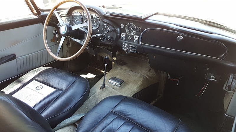 Interior of a classic car with vintage dashboard and leather seats.