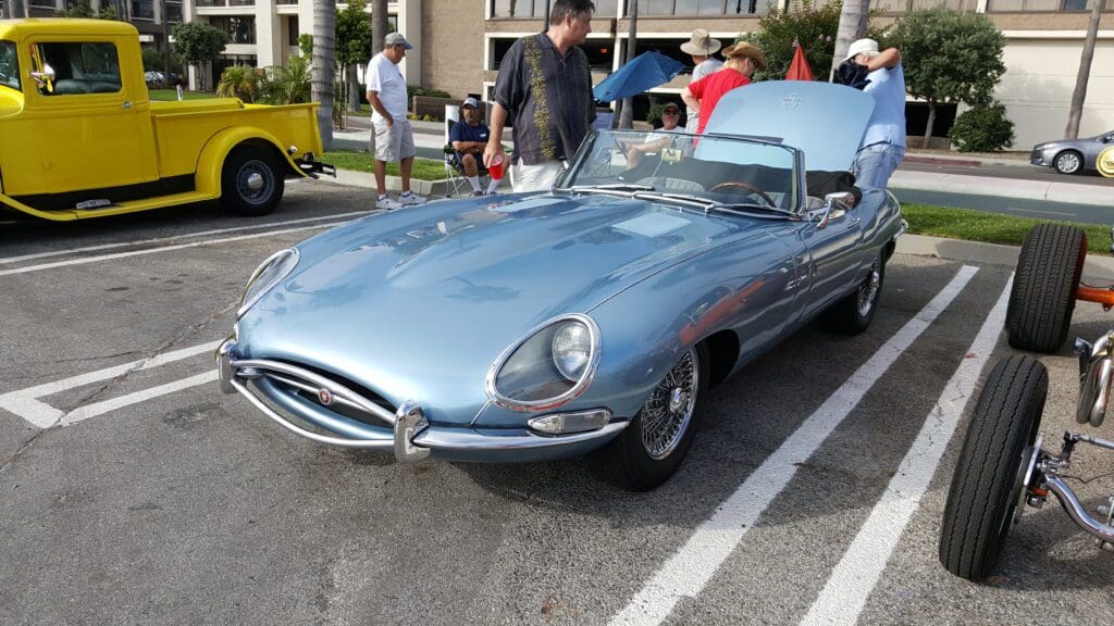 Classic blue Jaguar E-Type sports car displayed at a car show.